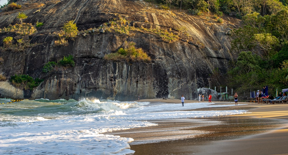 a group of people standing on top of a sandy beach