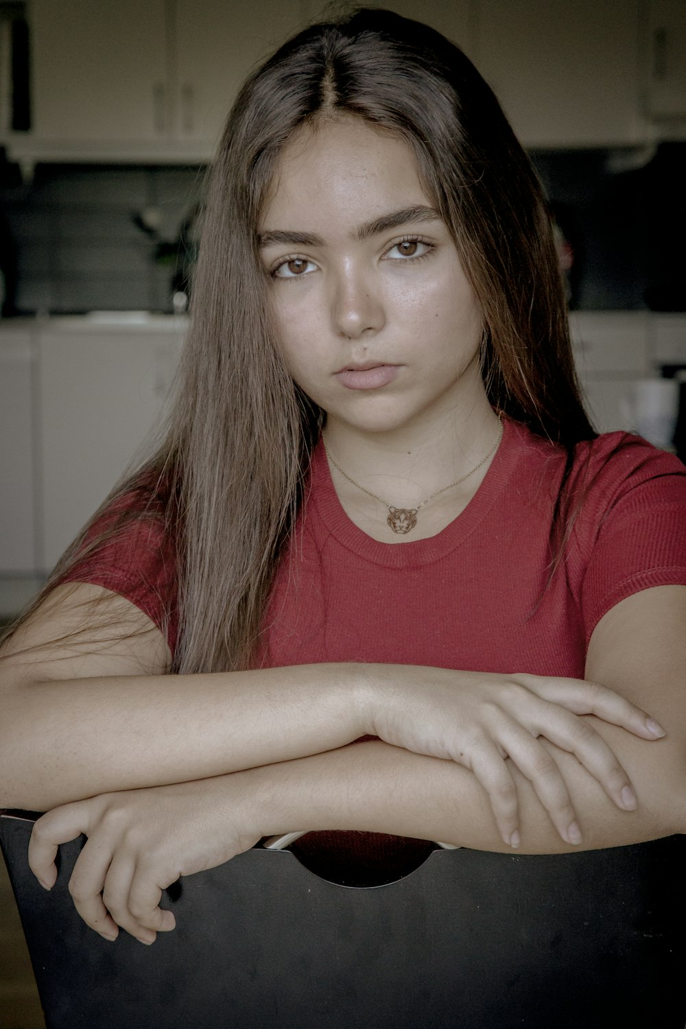 a woman sitting at a table with her arms crossed