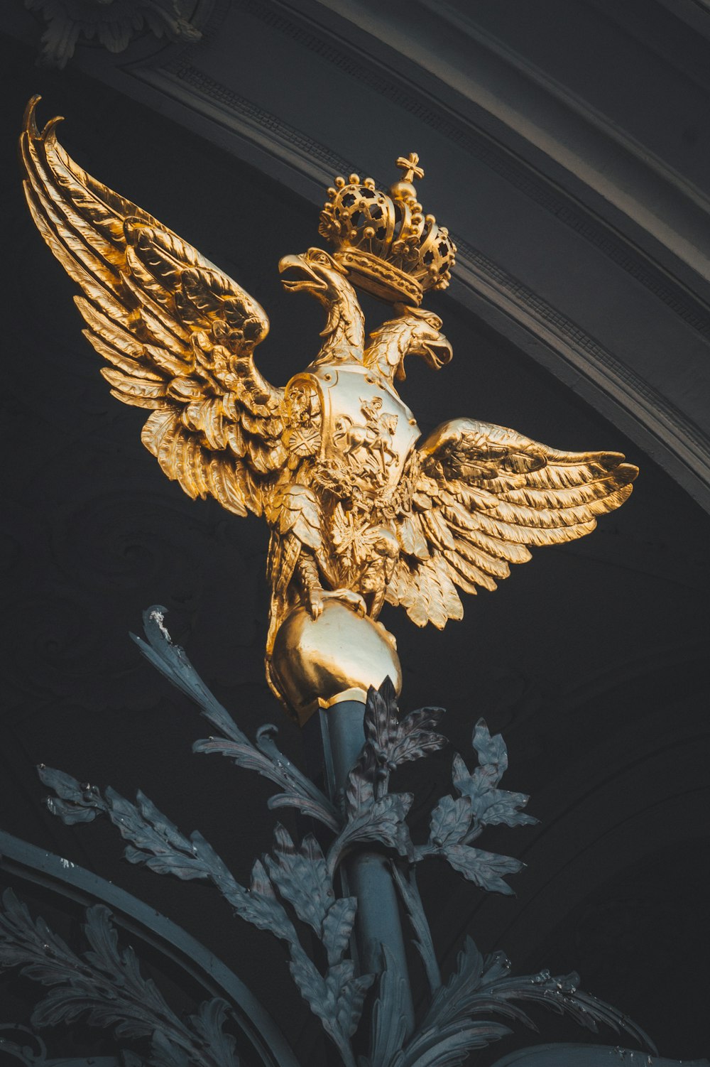 a golden statue of a bird with a crown on it's head