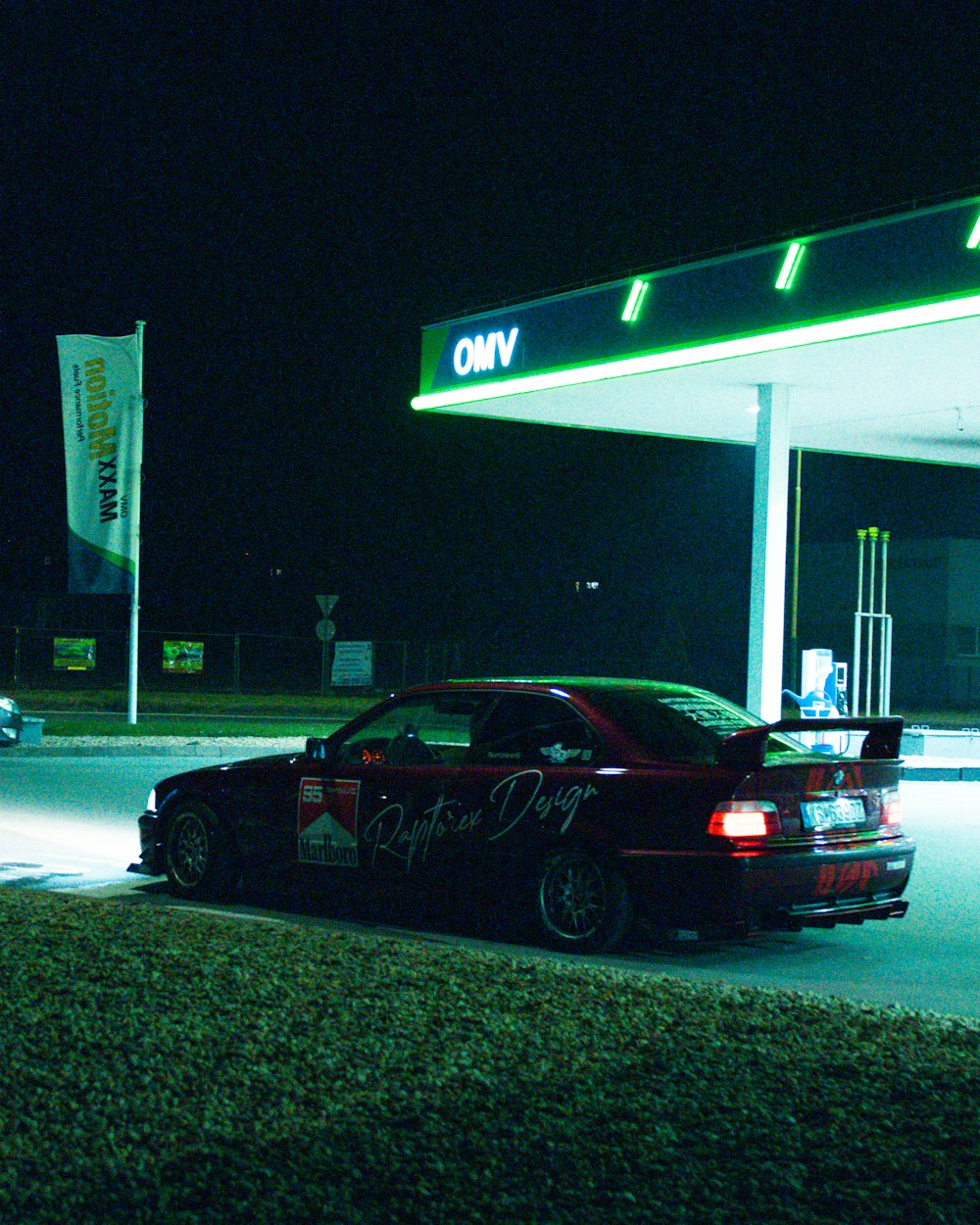 a car parked in front of a gas station at night