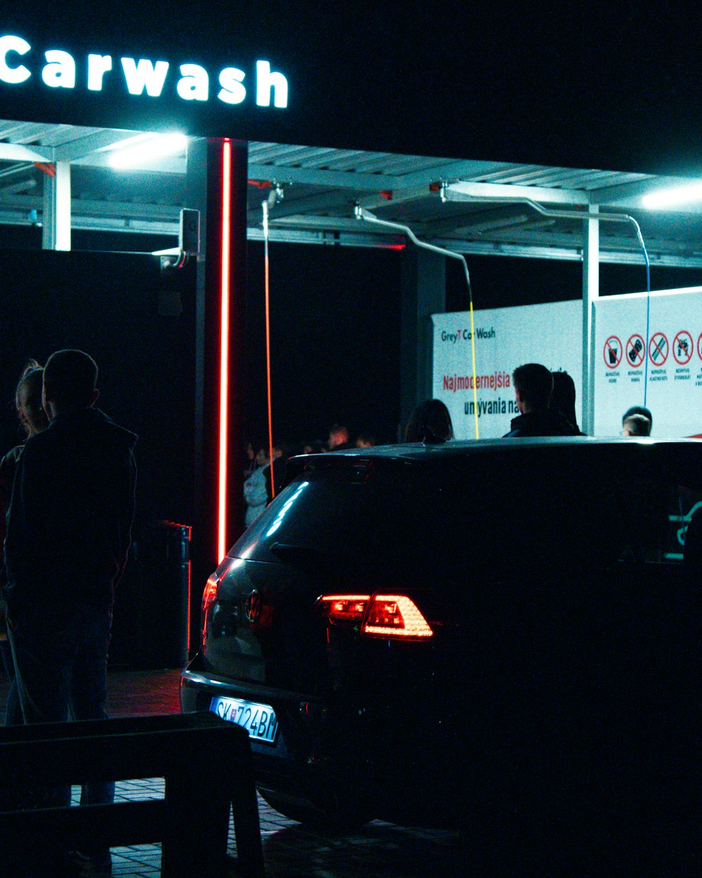 a group of people standing around a car wash