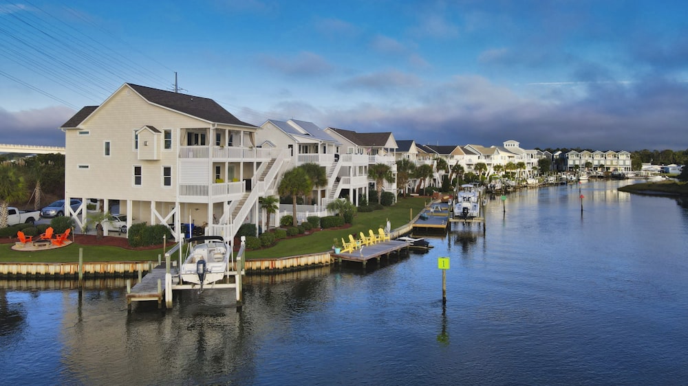 a row of houses on the water with a dock in front of them