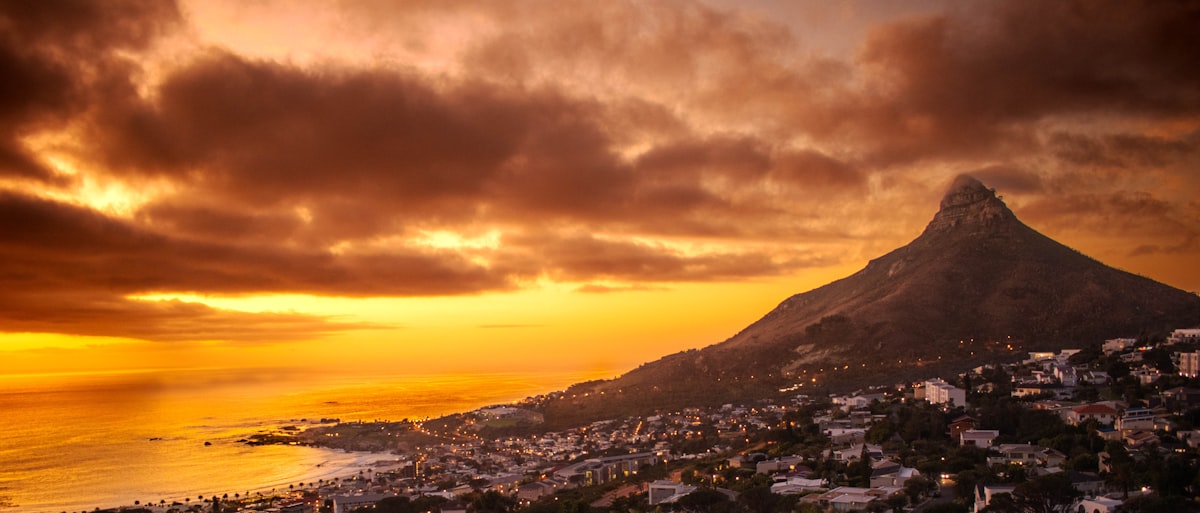 Camps Bay Cape Town — sunset over the beach boulevard with Lion's Head mountain rising above