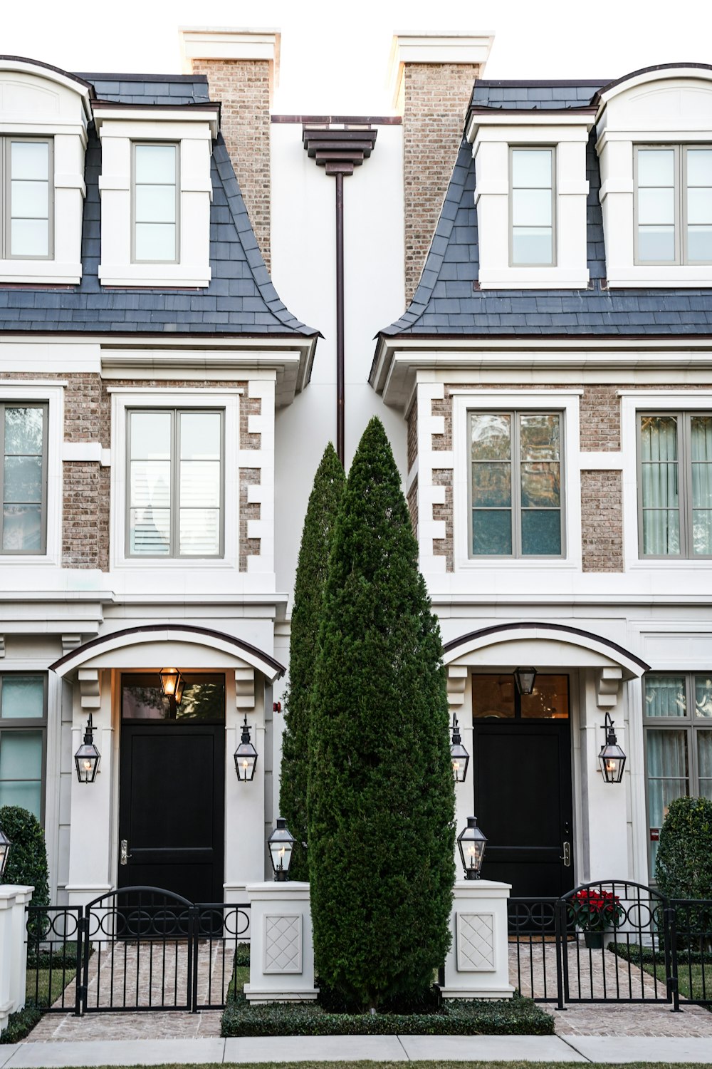 a couple of large white buildings with black doors