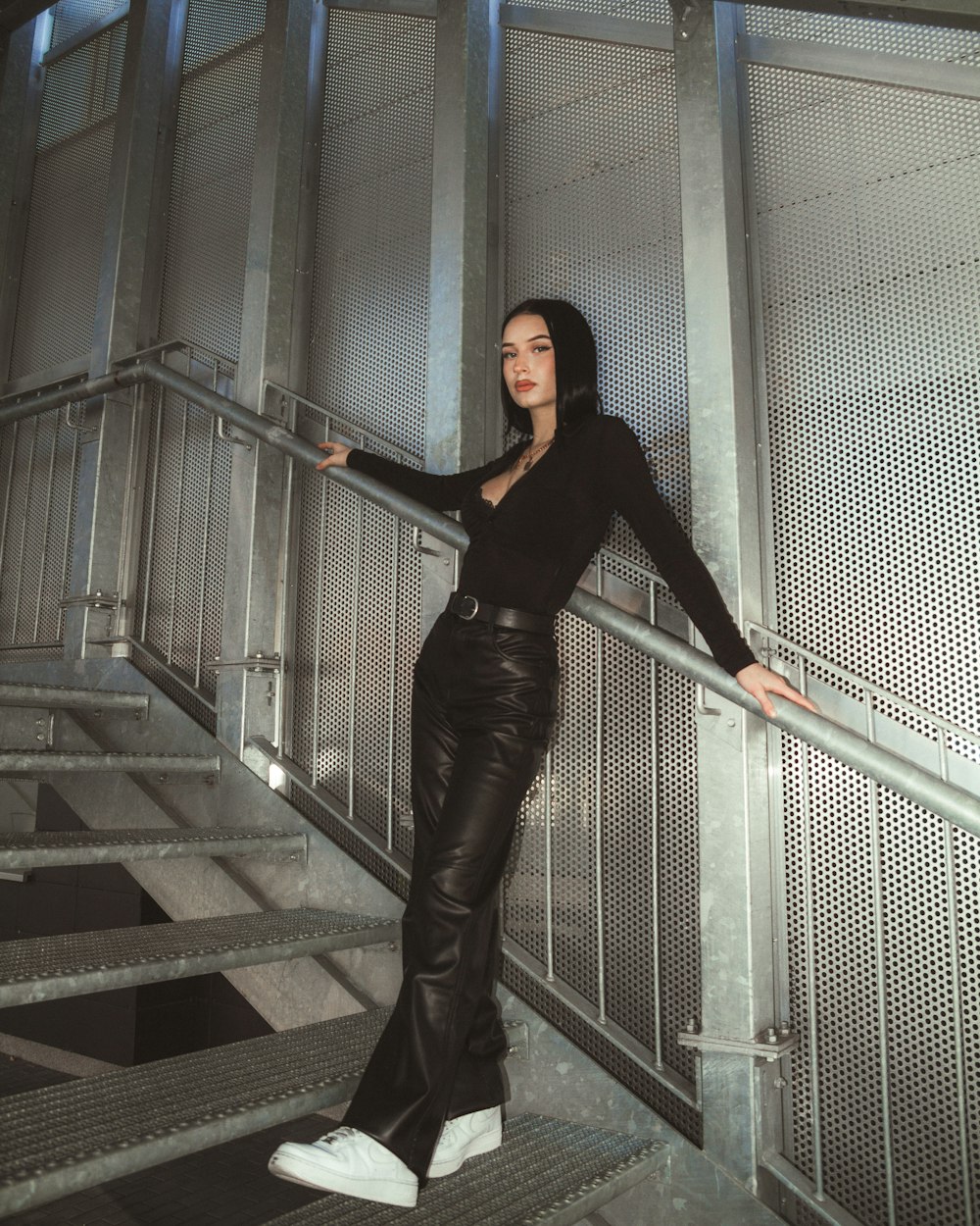 a woman leaning on a metal hand rail