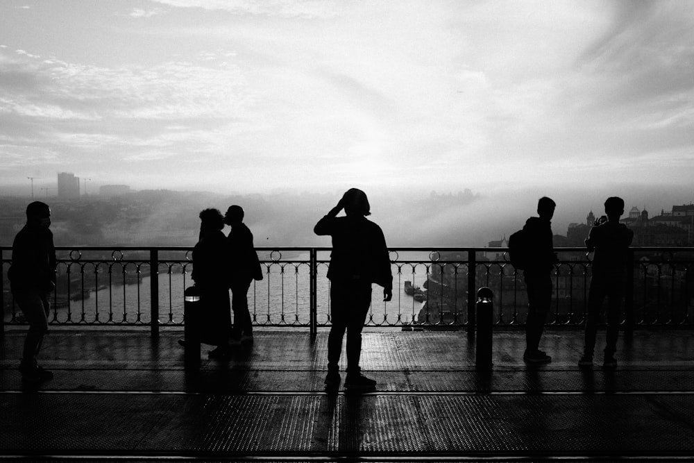 a group of people standing on top of a bridge