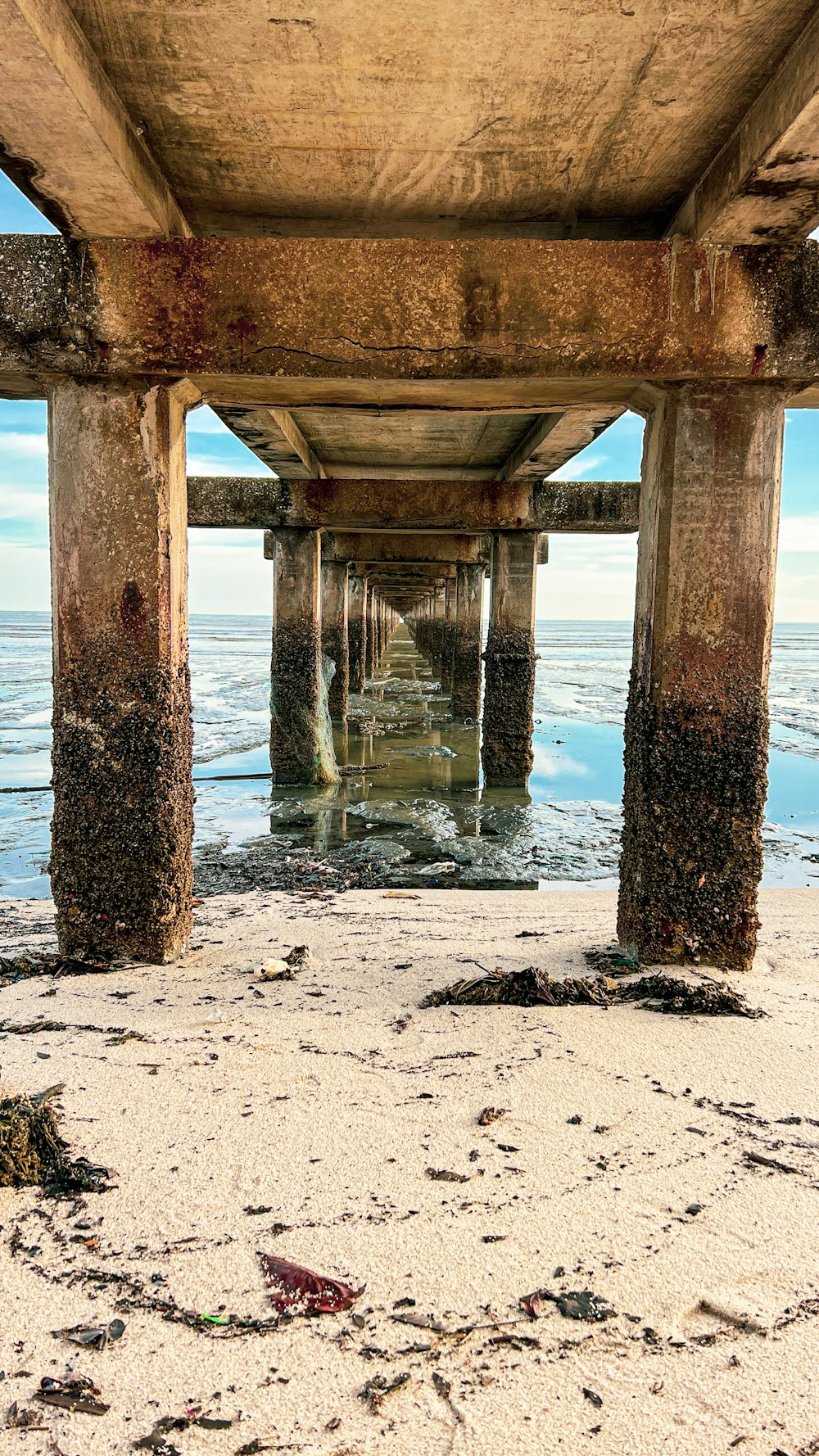 a view of the underside of a pier from the beach