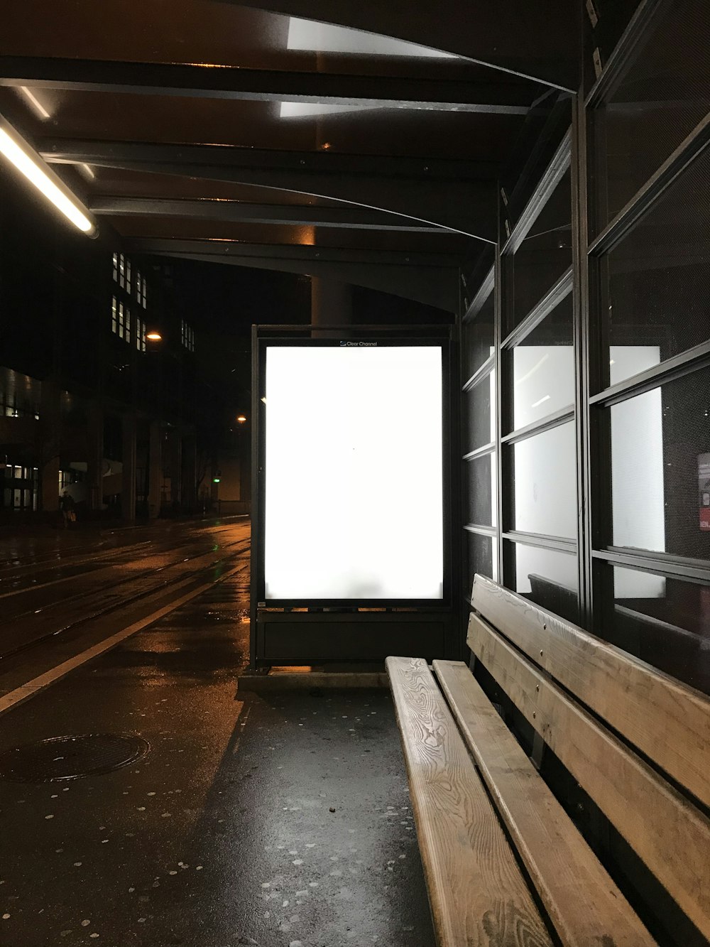 a wooden bench sitting next to a white board