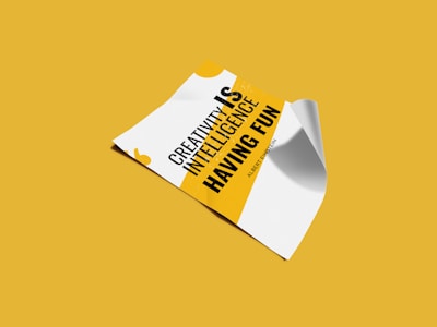 A piece of paper is displayed on a yellow background, featuring a motivational quote in bold black and yellow text. The paper appears slightly curled at the edges.