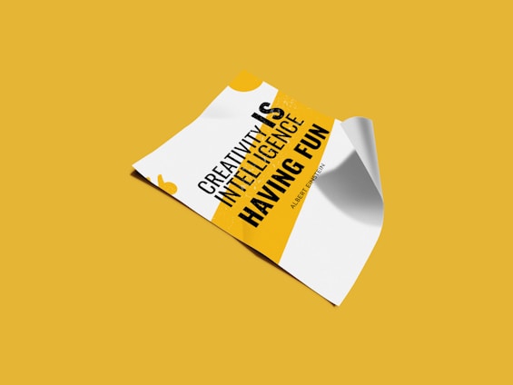 A piece of paper is displayed on a yellow background, featuring a motivational quote in bold black and yellow text. The paper appears slightly curled at the edges.