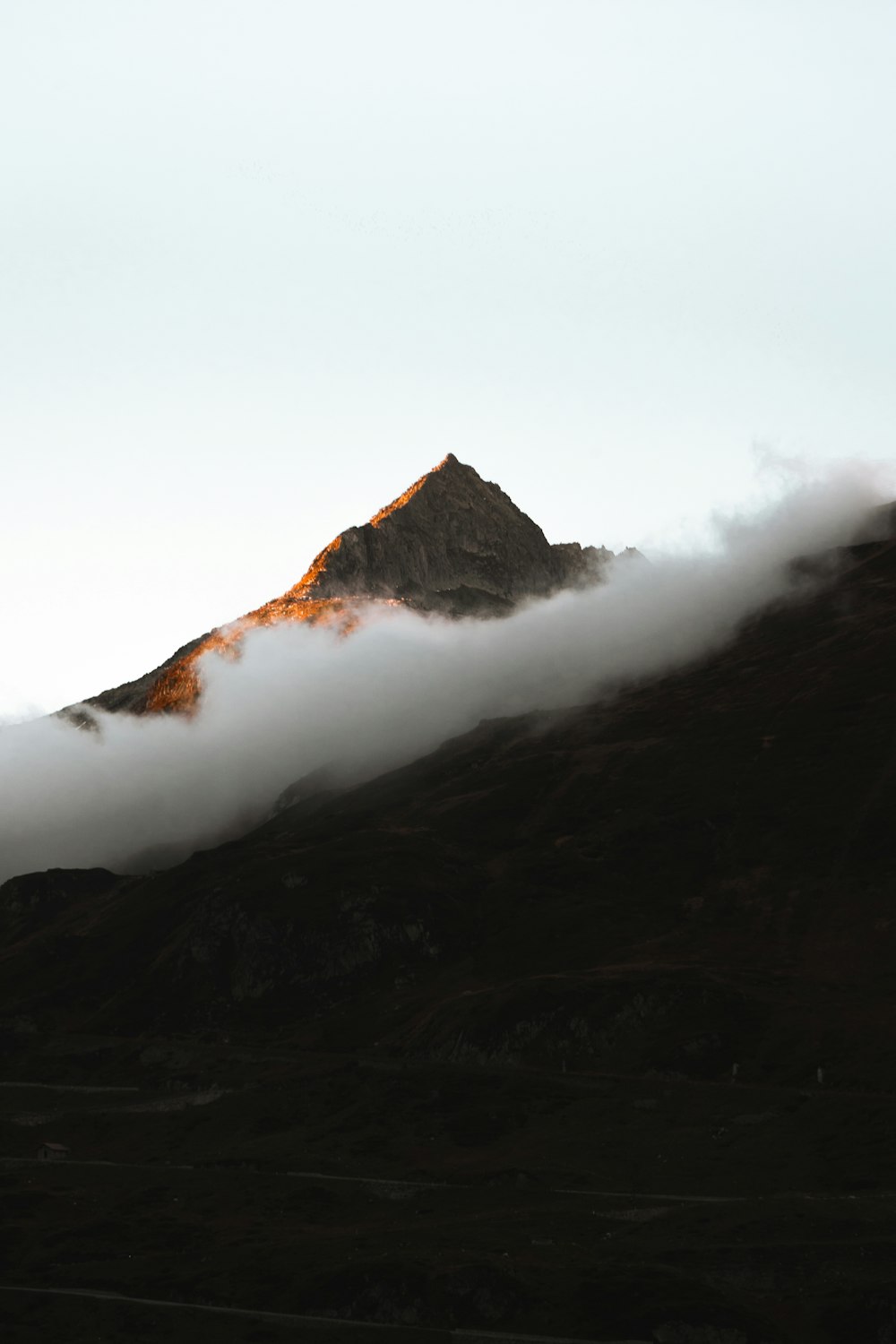 a mountain covered in clouds with a sky background