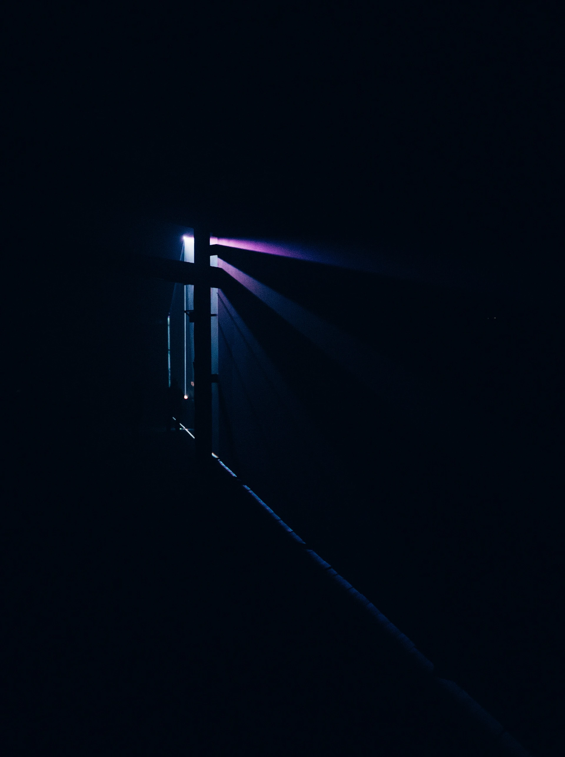 a dark room with a light coming from the ceiling
