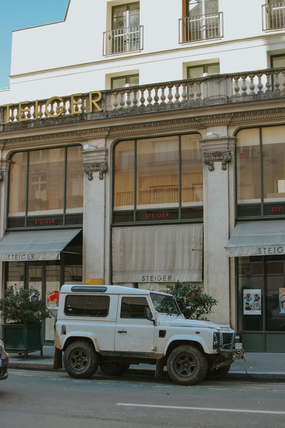 a white truck parked in front of a tall building