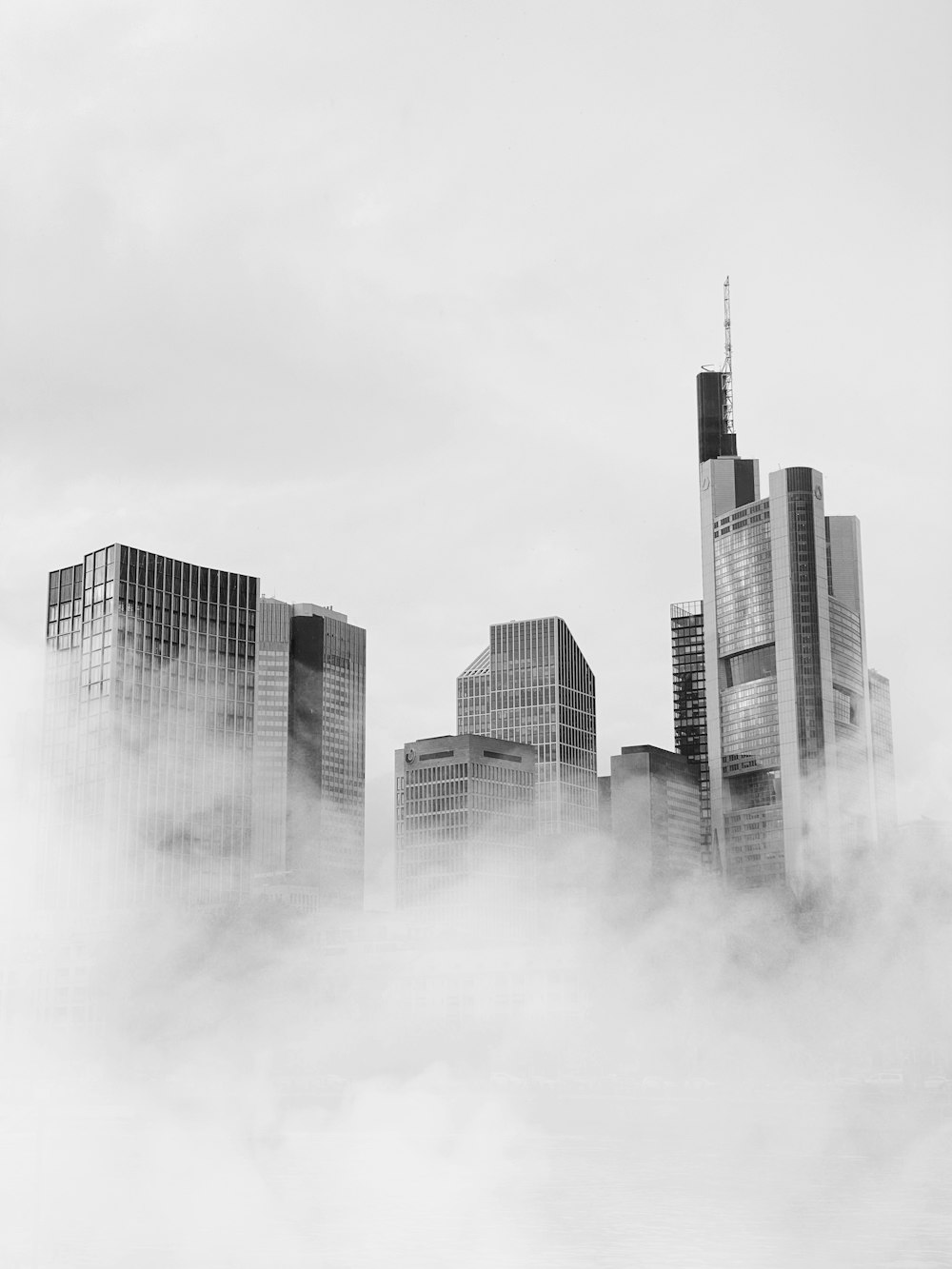 a black and white photo of a city in the clouds