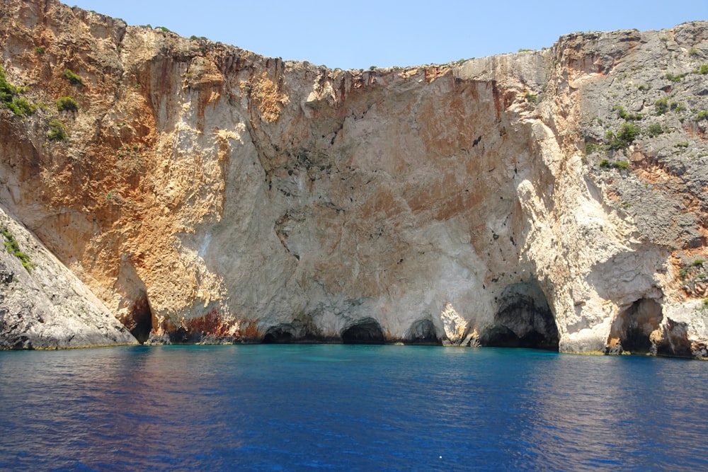 a large rock formation on the side of a body of water