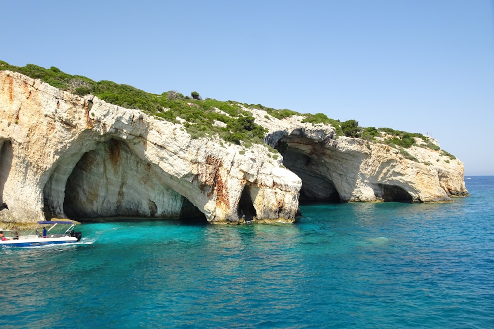 a boat in a body of water near a cliff