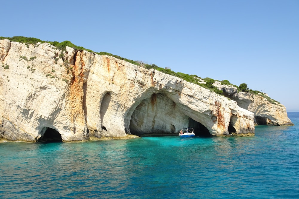 a boat in a body of water near a cliff