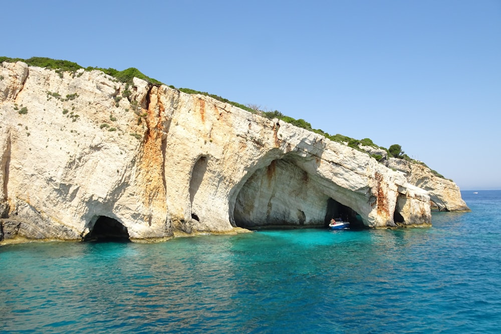 a boat is in the water near a large rock formation