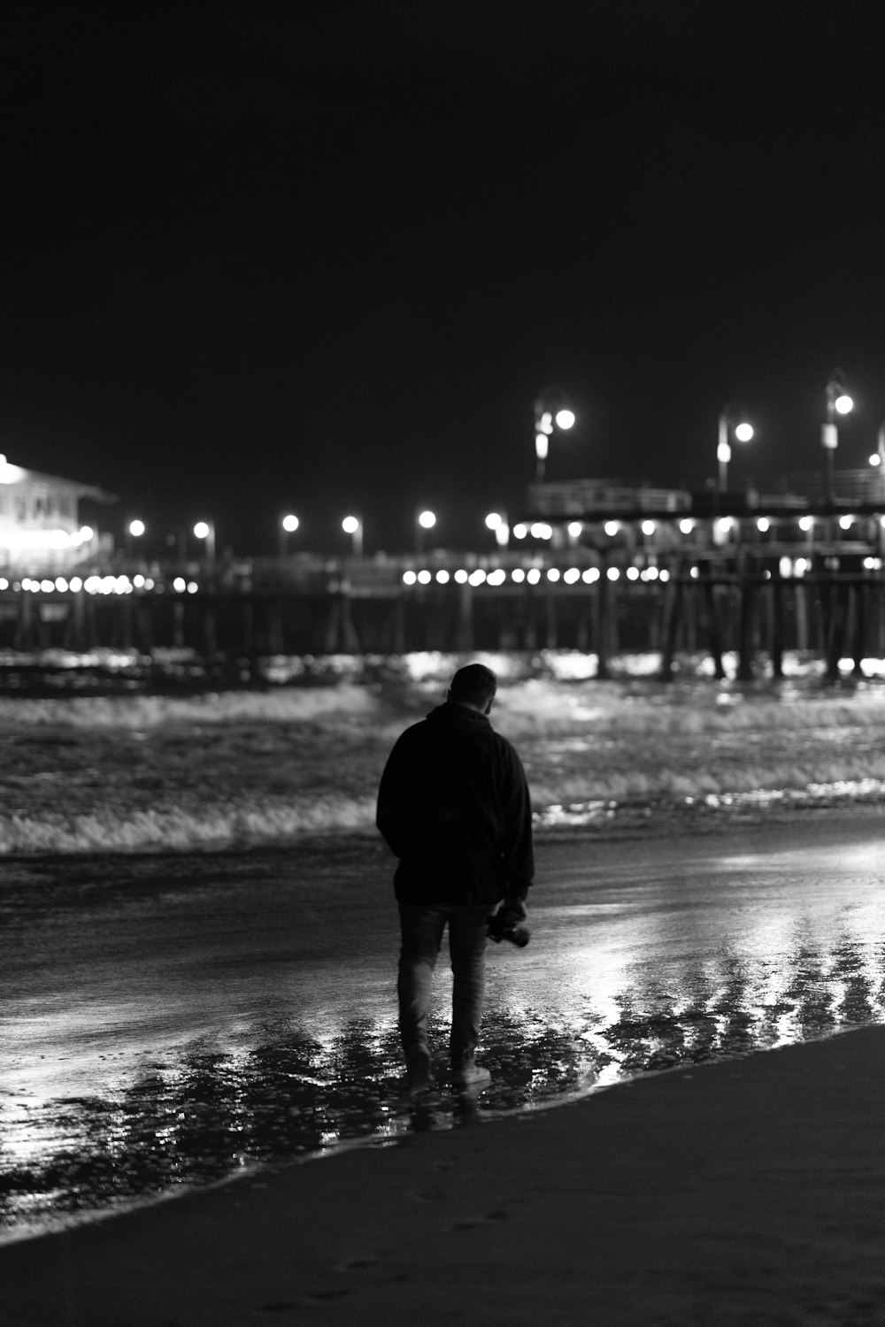 a man standing on a beach next to the ocean