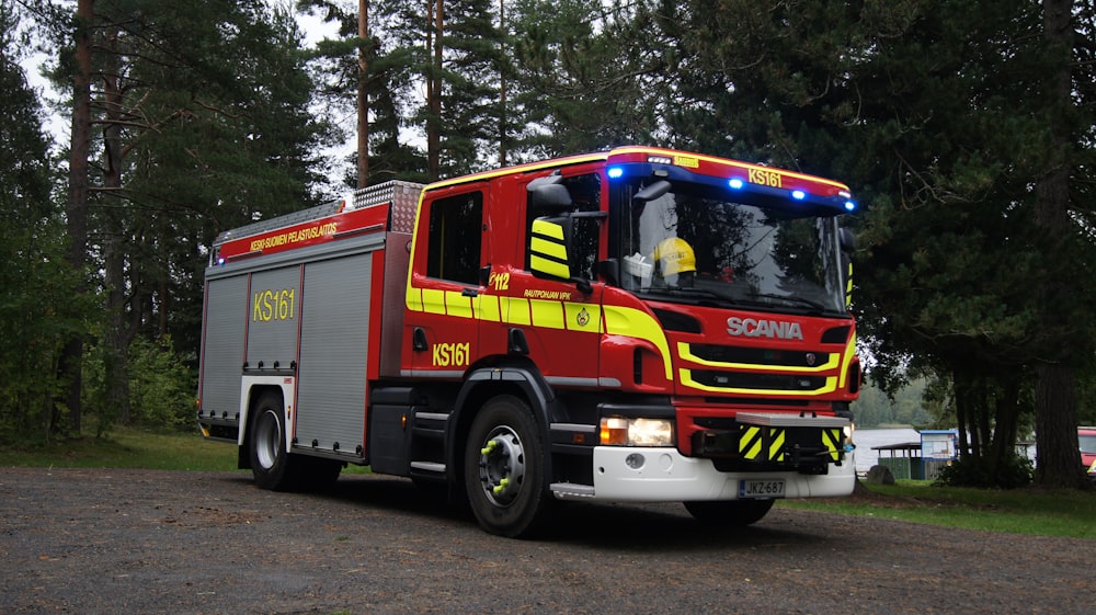 a red and yellow fire truck parked on the side of a road