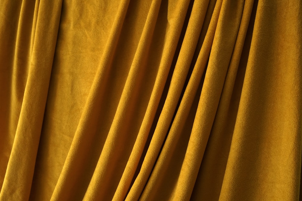 a close up of a curtain with yellow fabric