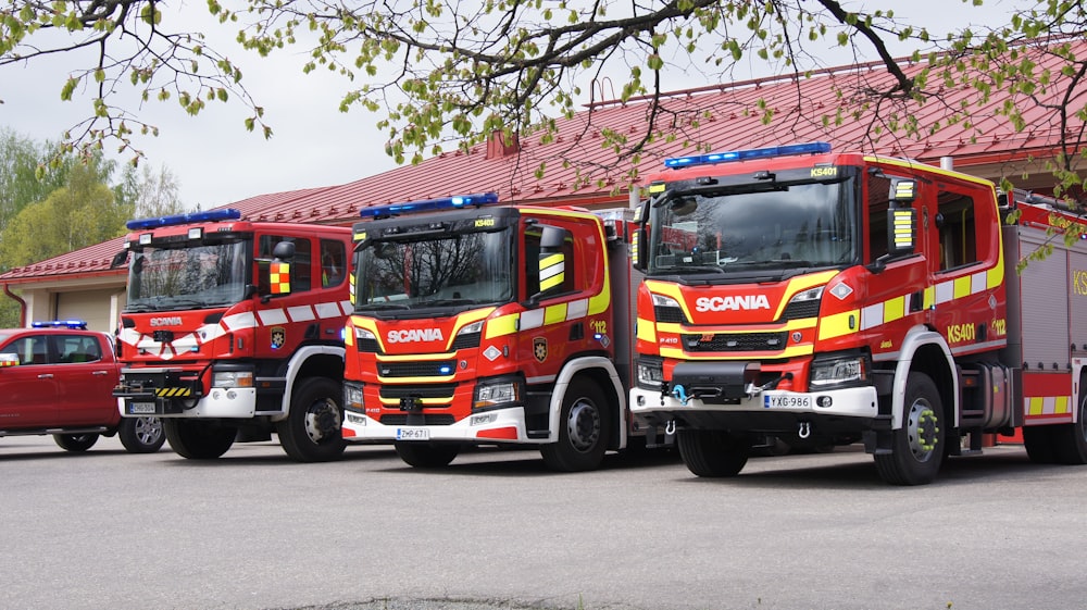 three fire trucks parked next to each other in a parking lot