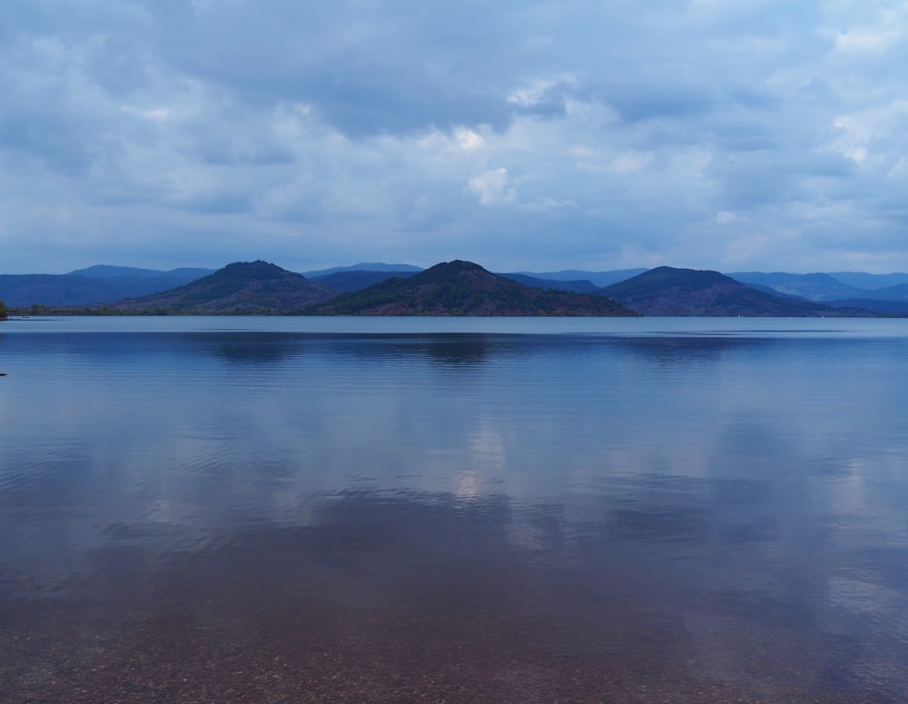 a large body of water with mountains in the background