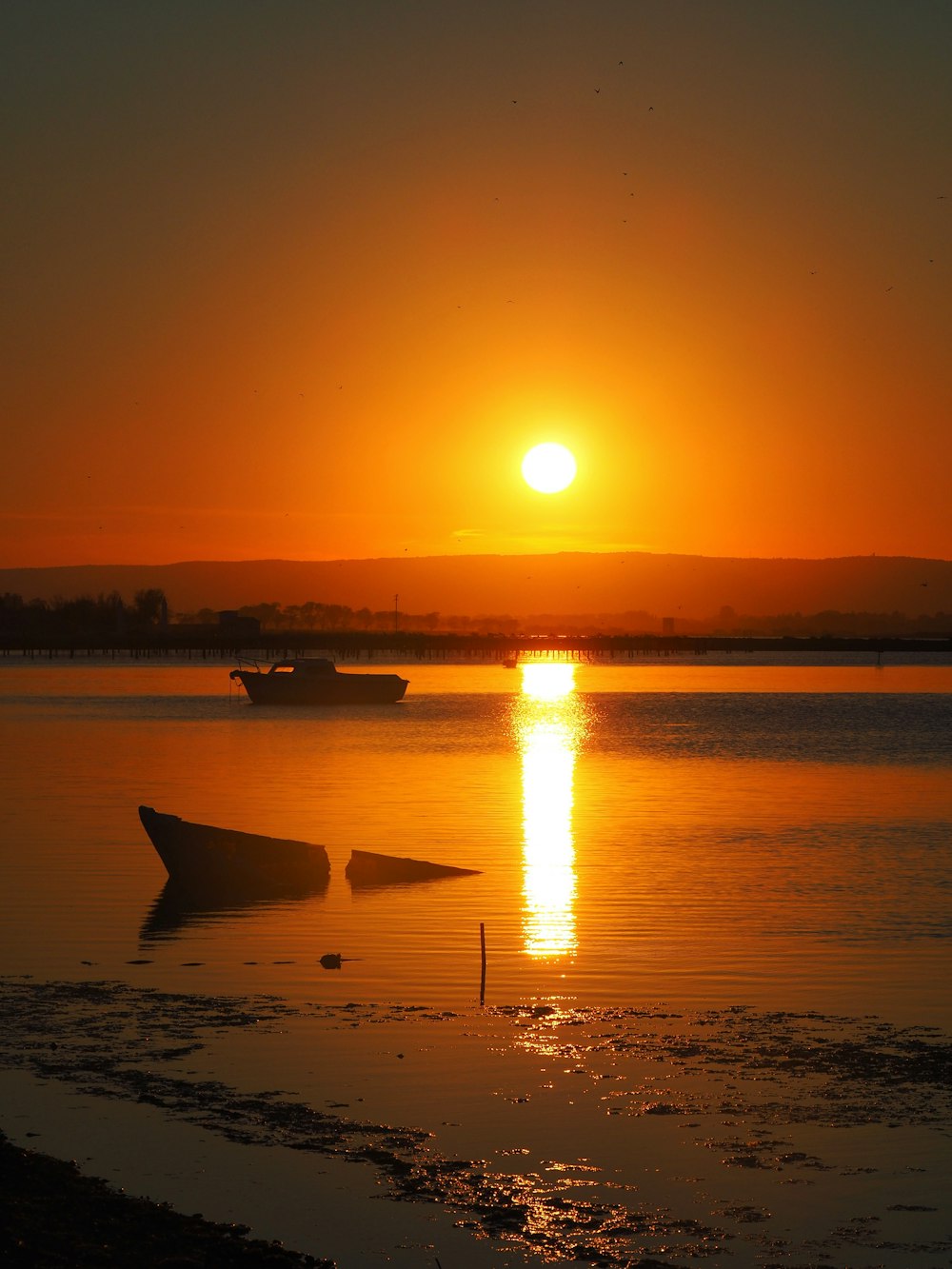 the sun is setting over a body of water