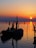 a boat is sitting in the water at sunset