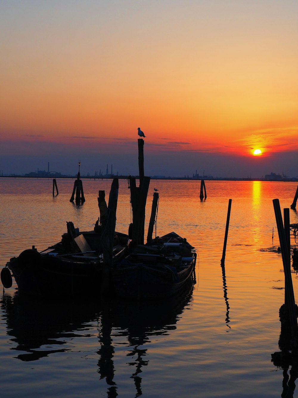 a boat is sitting in the water at sunset