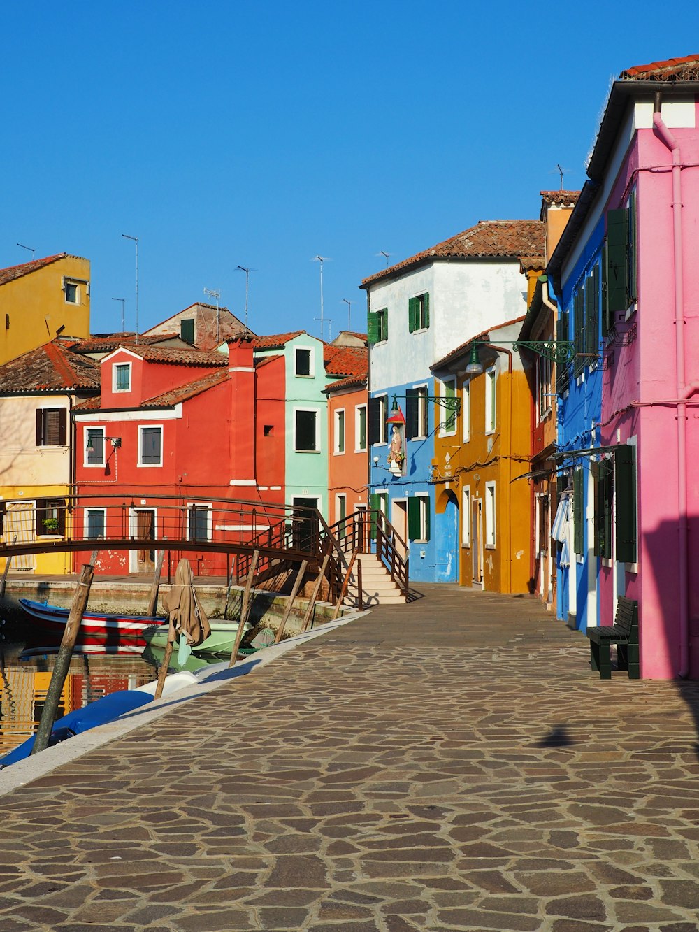 a cobblestone walkway leading to a row of colorful houses