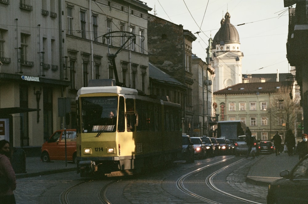 a yellow and white trolley on a city street