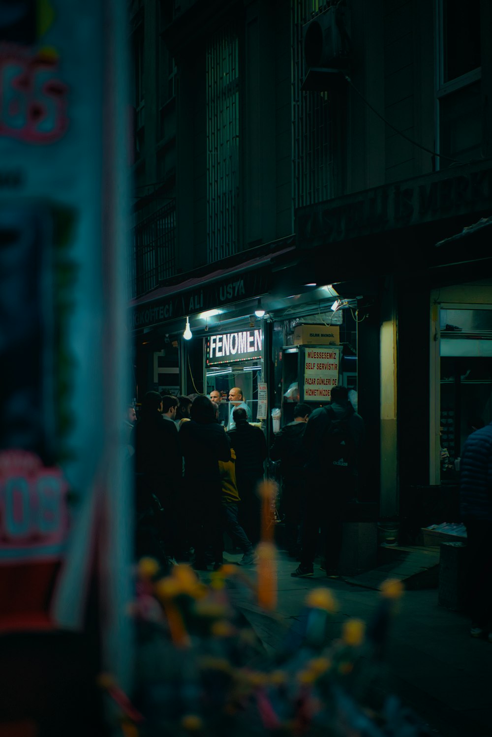 a group of people standing outside of a building at night