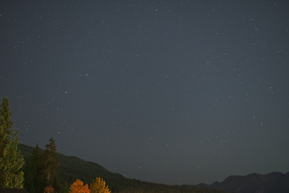 the night sky with stars above the mountains
