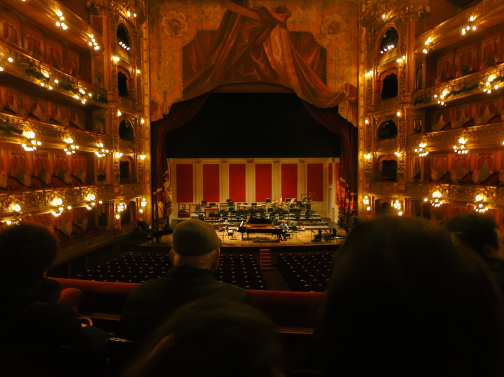 a stage with a conductor and orchestra in it