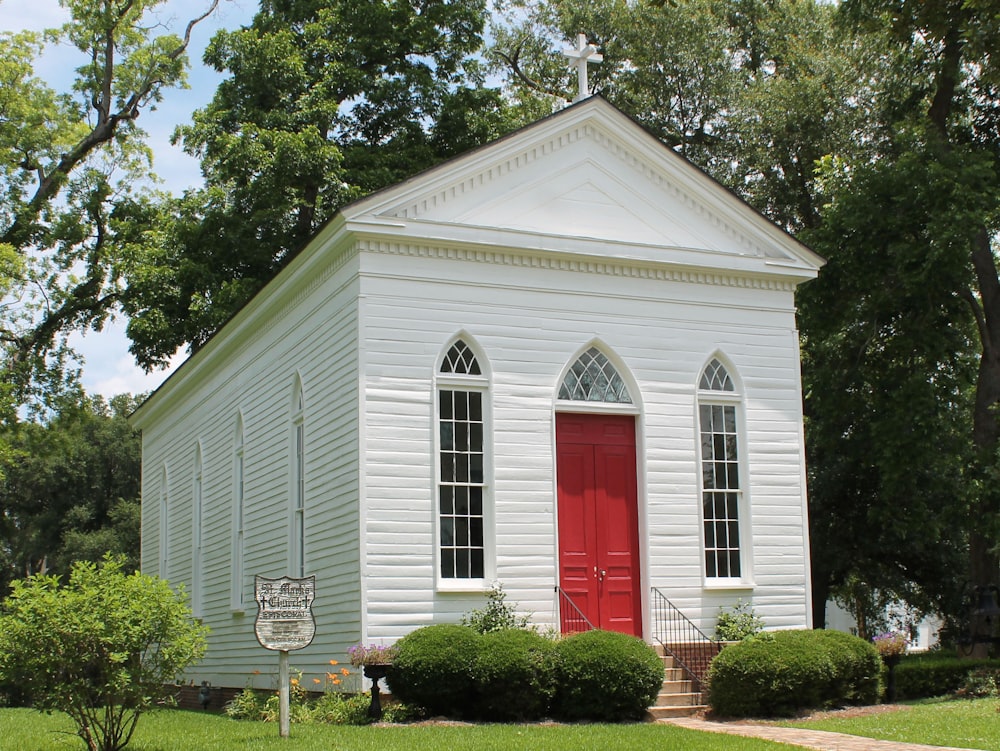 a small white church with a red door