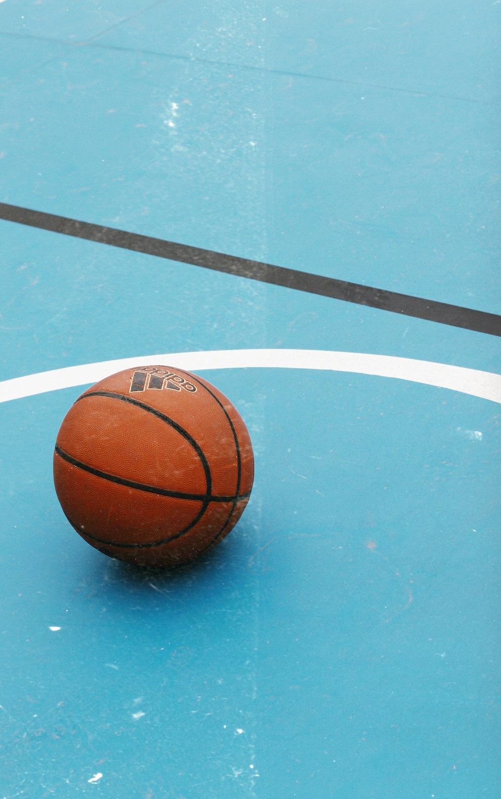 a basketball sitting on top of a blue court