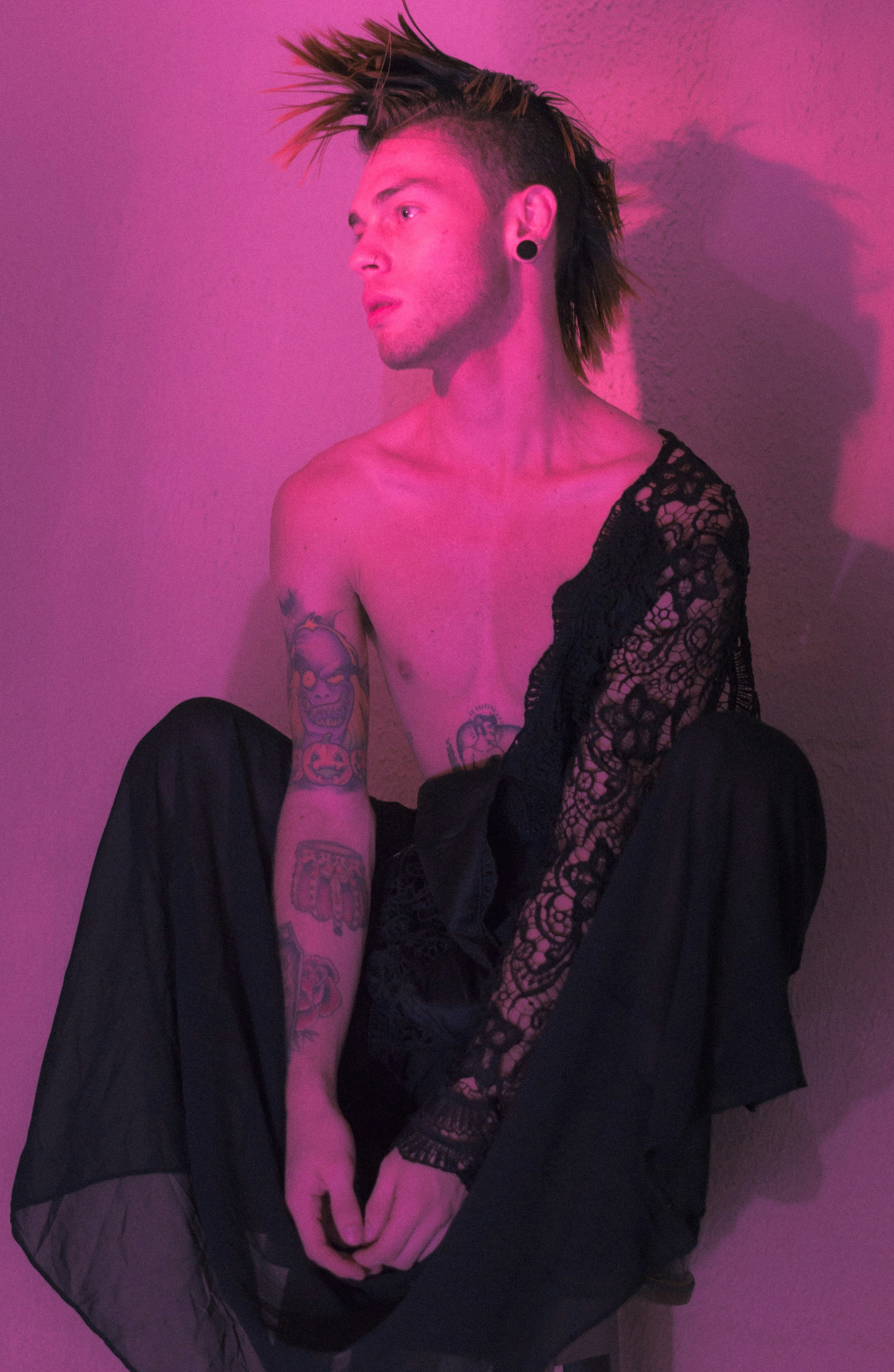 a man with a mohawk sitting on a stool
