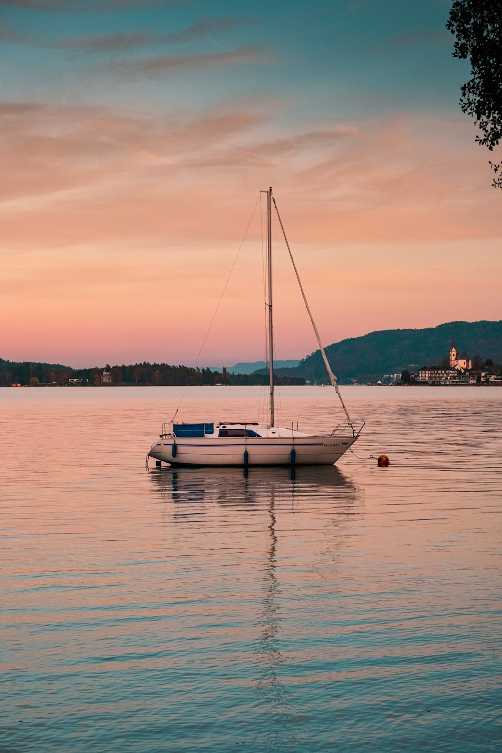 a sailboat floating on the water at sunset