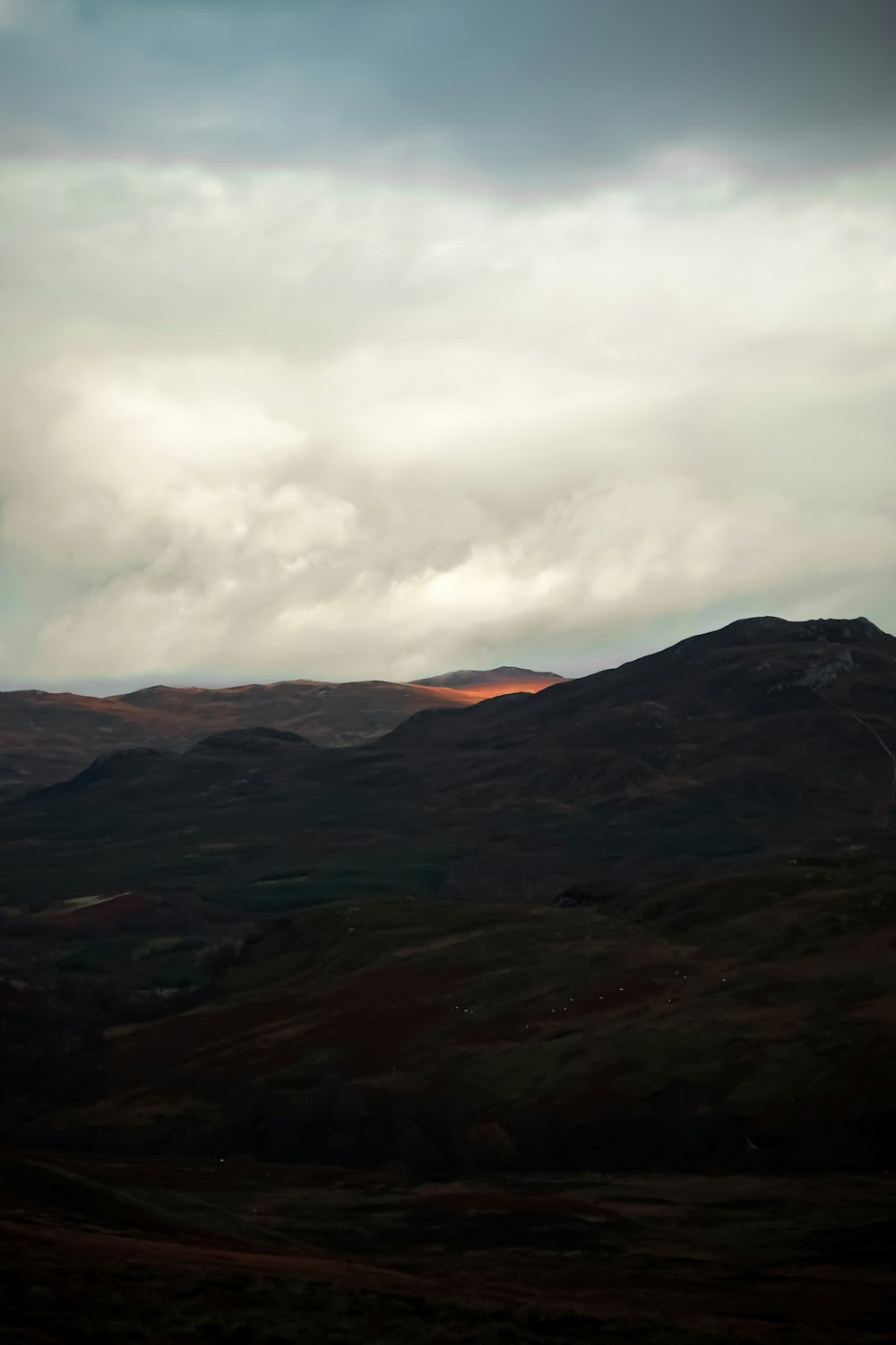 a view of a mountain range with clouds in the sky