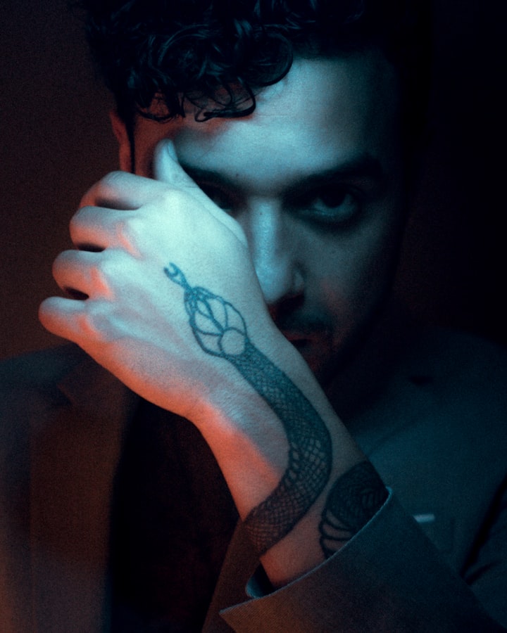 A serpentine snake tattoo winding down a man's arm, the curving line standing in for the wheat-stalk branches of flash design №012