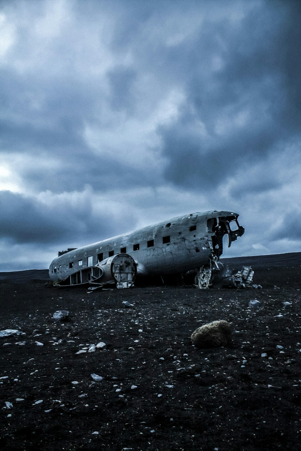 a plane sitting on top of a field under a cloudy sky