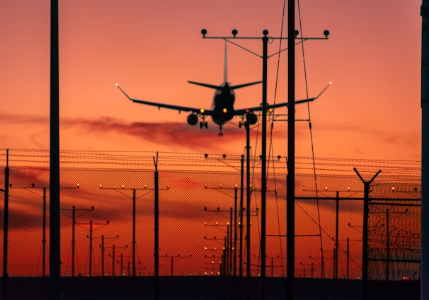 a plane is flying low over a fence