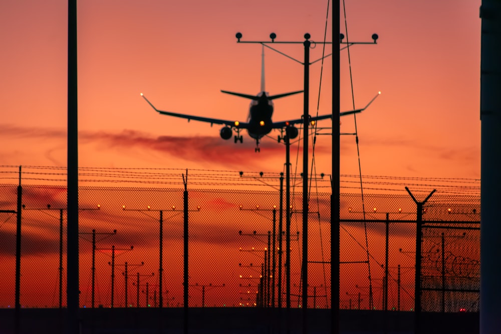 a plane is flying low over a fence