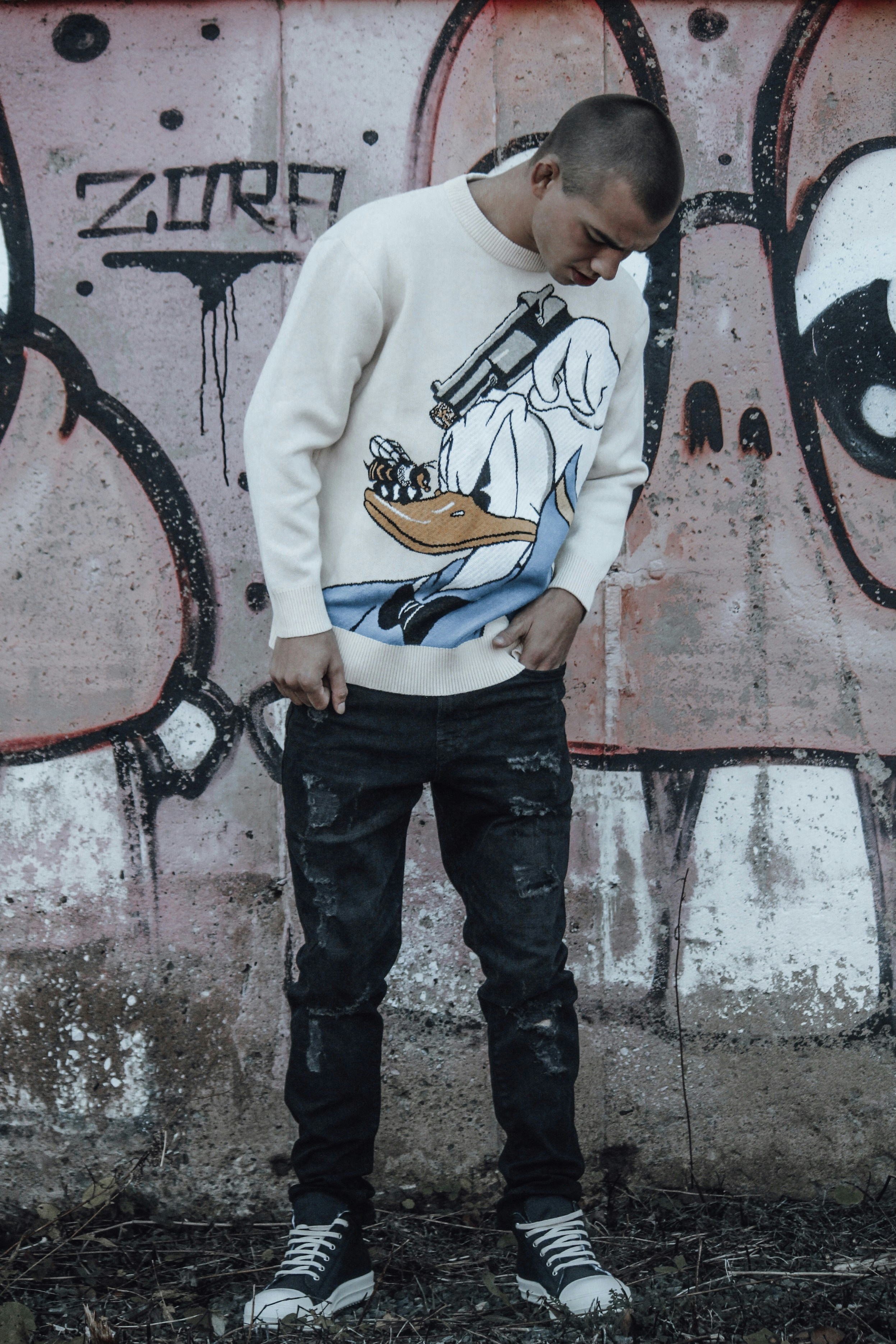 a man standing in front of a wall with graffiti