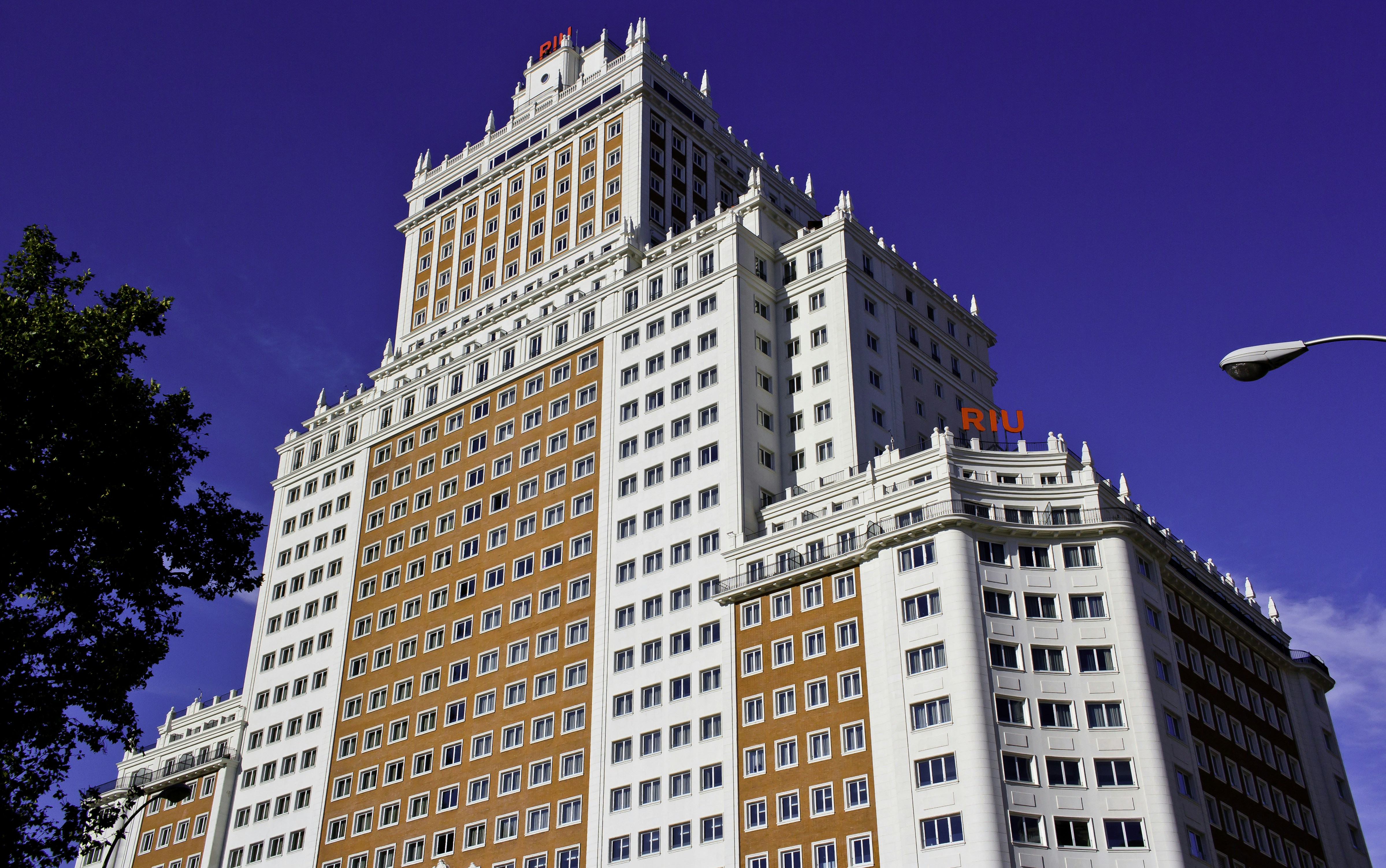 a tall white and brown building with windows, 