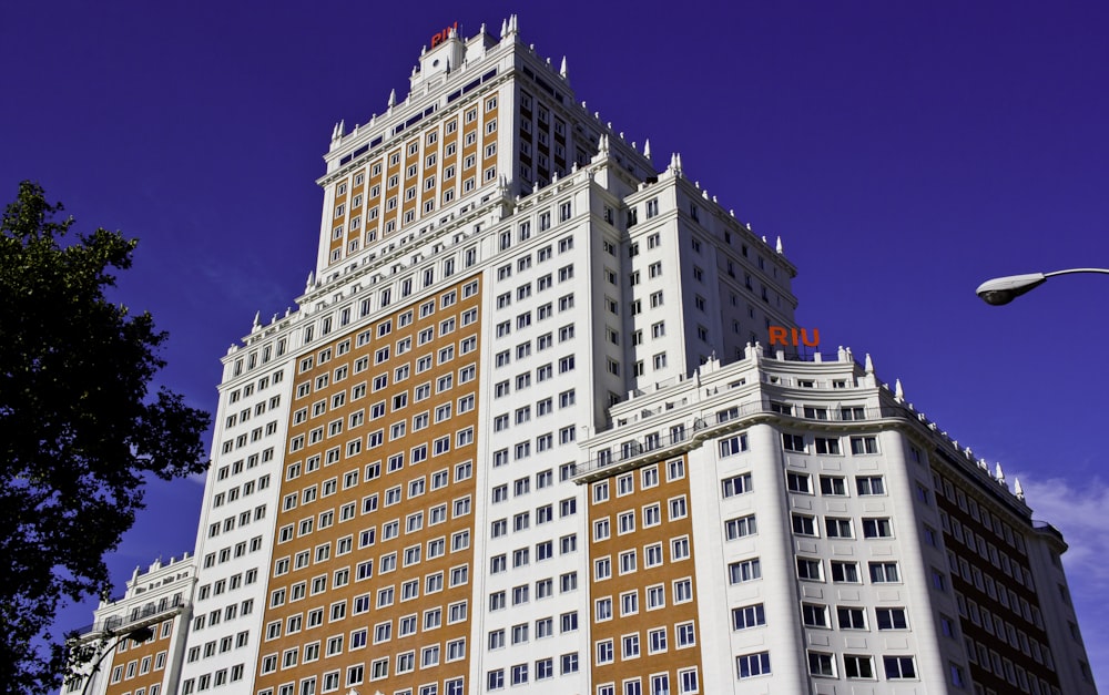 a tall white and brown building with windows