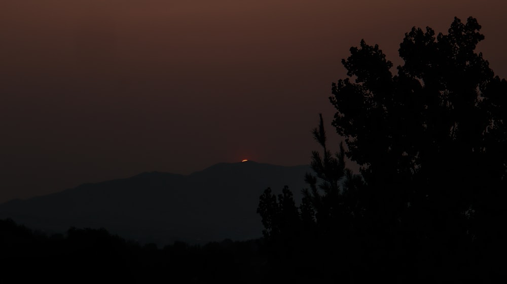 the sun is setting over the mountains in the distance