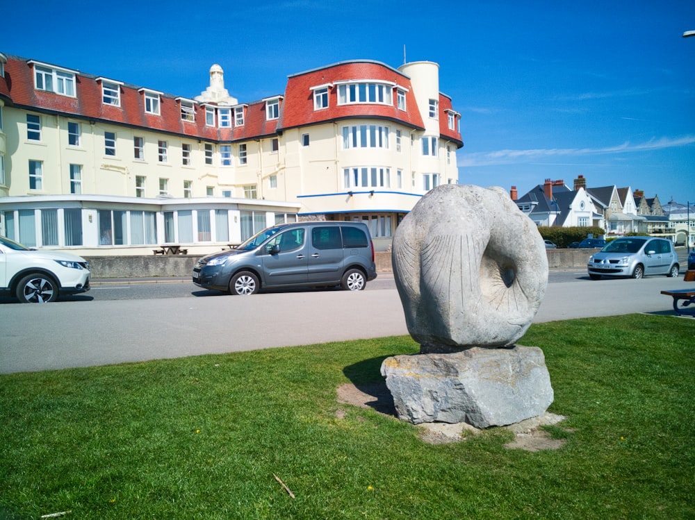 a sculpture of a donut on a rock in front of a hotel