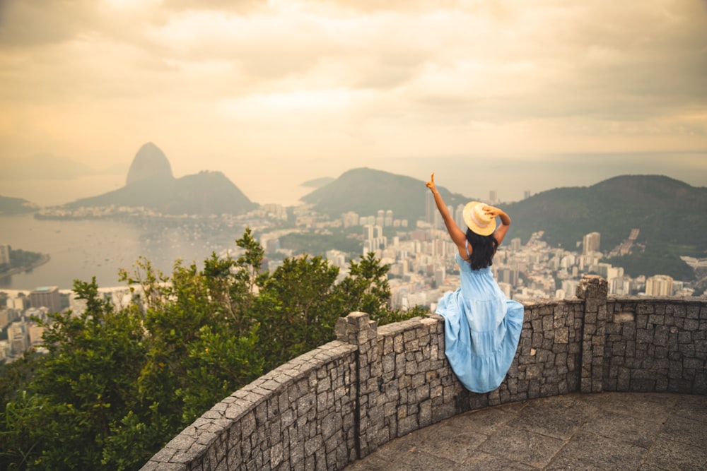 a woman standing on top of a stone wall